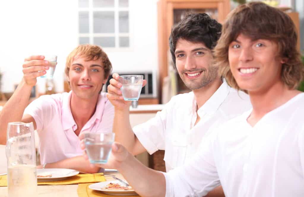 Three smiling man are drinking clean, filtered water