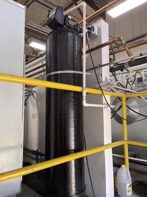 Clean commercial water softener installation with copper plumbing in a commercial facility