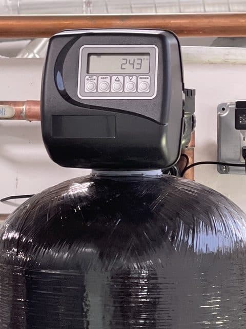 Close-up of the digital metered control valve on a commercial water softener